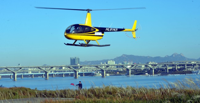 Seoul’s first tourist helicopter flies over the Hangang River on Wednesday. Run by Blue Airlines, the tour packages offer sightseeing on four routes including Jamsil and Yeouido.   Kim Myung-sub/The Korea Herald