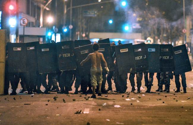A demonstrator protesting in demand of better working conditions and against police violence walks toward the police during clashes on “Teachers’ Day” on Tuesday in Rio de Janeiro, Brazil.   AFP-Yonhap News