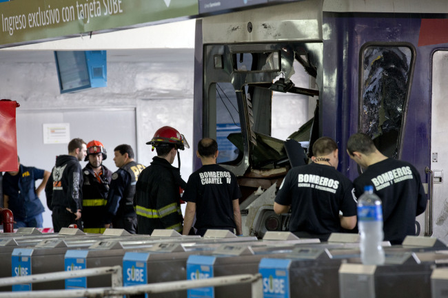 Police and firemen work on a commuter train that slammed into the end of the line when arriving to Once central station in Buenos Aires on Saturday.  AP-Yonhap News