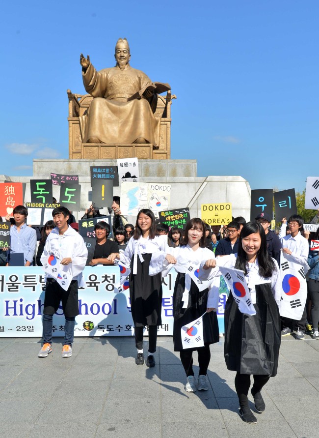 Students participating in a camp visiting Dokdo as part of the campaign to protect the sovereignty of the islets in the East Sea hold a ceremony in Gwanghwamun, Sunday.   Lee Sang-sub/The Korea Herald