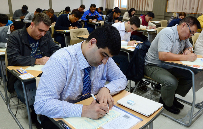 Foreigners take the state-run Korean proficiency test at Dongguk University in Seoul on Sunday. Lee Sang-sub/The Korea Herald