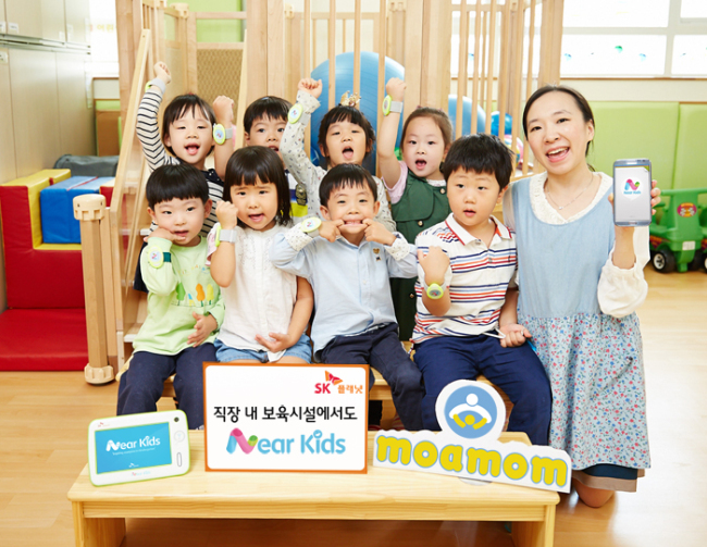 SK플래닛이 스마트 케어 서비스 ‘니어키즈(Near Kids)’를 직장보육시설로 확대 제공한다. 서울 동대문세무서에 위치한 국세청 동대문 우리누리 어린이집에서 NFC태그가 부착된 팔찌를 찬 어린이들이 포즈를 취하고 있다.   [사진제공=SK플래닛]