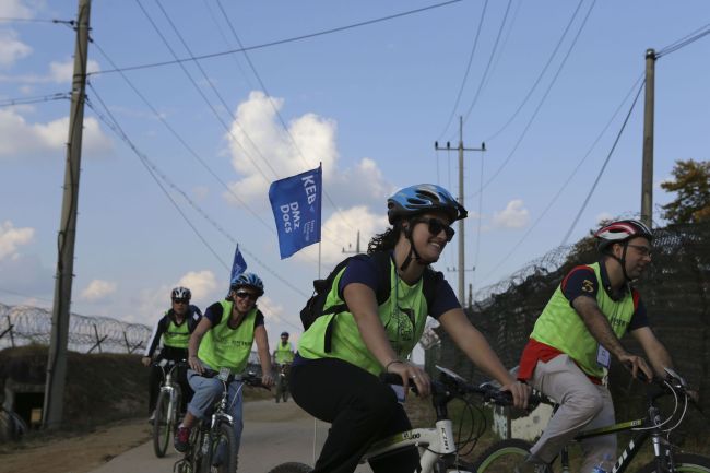 Korea Exchange Bank officials and expat customers participate in the “DMZ & Peace Bicycle Tour” near the inter-Korean Demilitarized Zone on Sunday. The tour is a part of KEB’s “Omega Service” designed to help its international customers understand Korean history.   KEB