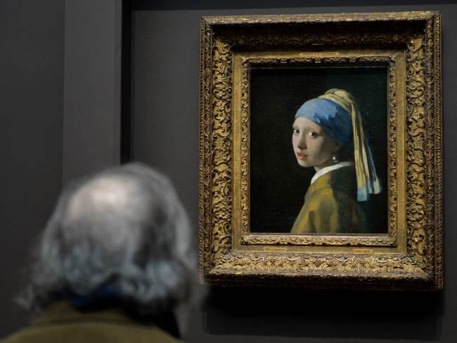 A man views “Girl with a Pearl Earring” by Johannes Vermeer in the exhibition “Vermeer, Rembrandt, and Hals: Masterpieces of Dutch Painting from the Mauritshuis” on Monday at the Frick Collection in New York.   AFP-Yonhap News