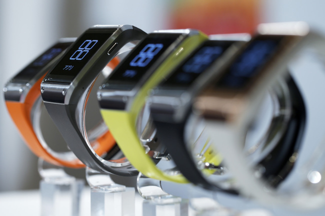 Samsung Electronics Co.’s Galaxy Gear wearable devices for KDDI Corp.’s “au” brand sit on display during a product launch event in Tokyo, Oct. 2.   Bloomberg