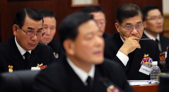 Senior Navy officers look on as Chief of Naval Operations Adm. Hwang Ki-chul (center) is grilled by lawmakers over the controversial construction of a strategic naval base on Jeju during a parliamentary audit in the Gyeryongdae military headquarters in South Chungcheong Province on Wednesday.   Yonhap News