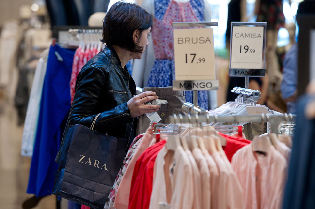 A customer inspects clothes on display inside a Mango fashion store in Barcelona.    Bloomberg