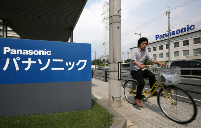A man rides a bicycle past the Panasonic Corp. headquarters in Kadoma, Japan.   Bloomberg