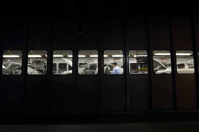 A worker prepares to paint a vehicle at a plant operated by Dongfeng Peugeot-Citroen Automobile Ltd. in Wuhan, China.   Bloomberg