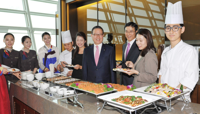 Asiana Airlines CEO Yoon Young-doo (sixth from left) poses with company officials and customers at the airline’s refurbished business lounge at Incheon International Airport on Thursday.   Asiana Airlines