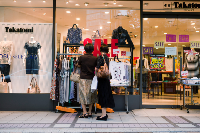 Women browse clothing outside a Takatomi store in the Ginza area of Tokyo.   Bloomberg