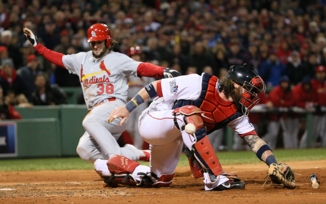 Boston Red Sox catcher Jarrod Saltalamacchia is unable to handle the throw from left fielder Jonny Gomes as St. Louis Cardinals pinch runner Pete Kozma scores on a sacrifice fly by Matt Carpenter in the seventh inning during Game 2 of the World Series between the St. Louis Cardinals and the Boston Red Sox at Fenway Park in Boston on Thursday.   AP-Yonhap News