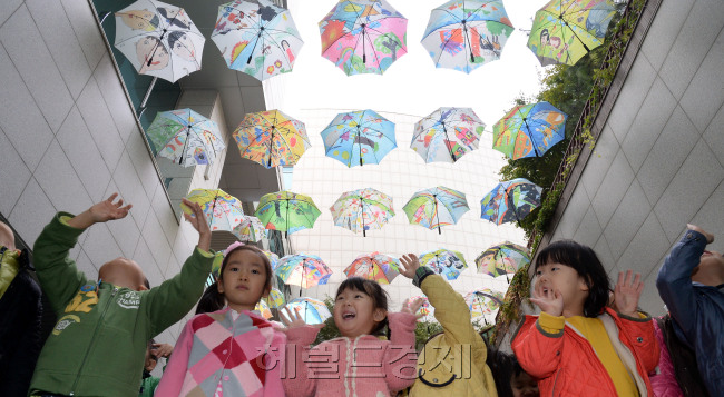 동심 담긴 하늘 우산 보고가세요. 성동구청이 28일 오전 지하1층 앞마당에 관내 어린이집 원아들의 꿈과 희망을 담아 디자인한 우산 49개를 전시하고 '하늘우산 갤러리'를 열고 있다. 성동구는 이곳을 지나가는 모든 사람들에게 새롭고 흥미로운 볼거리를 신사 할 것을 기대하고 있다./안훈기자 rosedale@ 2013.10.28
동심 담긴 하늘 우산 보고가세요. 성동구청이 28일 오전 지하1층 앞마당에 관내 어린이집 원아들의 꿈과 희망을 담아 디자인한 우산 49개를 전시하고 '하늘우산 갤러리'를 열고 있다. 성동구는 이곳을 지나가는 모든 사람들에게 새롭고 흥미로운 볼거리를 신사 할 것을 기대하고 있다./안훈기자 rosedale@ 2013.10.28