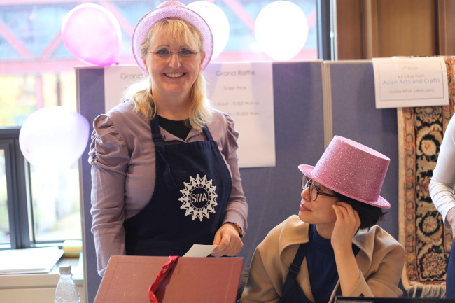 Maria Seidl, Seoul International Women’s Association treasurer, helps run the Grand Raffle at last year’s SIWA Bazaar.   SIWA