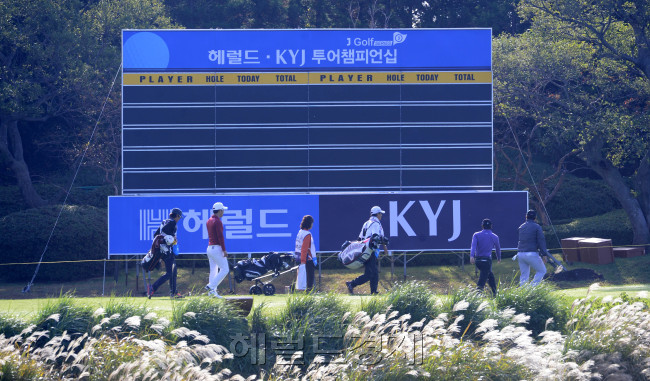 올시즌 마지막 KPGA 대회인 '헤럴드 KYJ 투어챔피언십'이 29일 오전 제주 서귀포시 롯데스카이힐 골프장 힐ㆍ오션 코스(파72ㆍ7228야드)에서 열린 가운데 1라운드 경기에서 출전선수들 갈대밭 뒤로 걸어가고  있다. [제주=박해묵 기자/mook@heraldcorp.com]
헤럴드 KYJ 투어 챔피언십에 참가한 선수들과 캐디들이 티샷을 하기 위해 전광판 앞을 지나고 있다. 아래로는 가을의 정취를 풀씬 풍기는 억새가 바다를 건너온 바람에 눈이 부시게 흔들리고 있다.