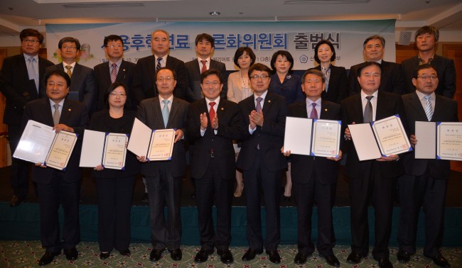 Minister of Trade, Industry and Energy Yoon Sang-jick (fourth from left, front row) poses during a ceremony appointing 15 members to a panel on spent nuclear fuel in Seoul on Wednesday.   Lee Sang-sub/The Korea Herald