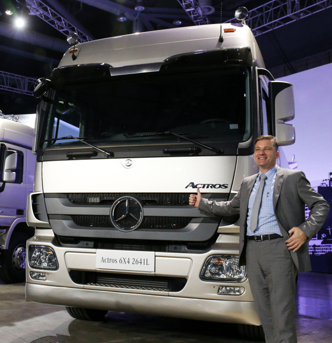 Daimler Trucks Korea sales and marketing vice president Rainer Gaertner poses next to the Actros Cargo truck during a launching event held at KINTEX in Goyang, Gyeonggi Province, Wednesday.   Daimler Trucks Korea