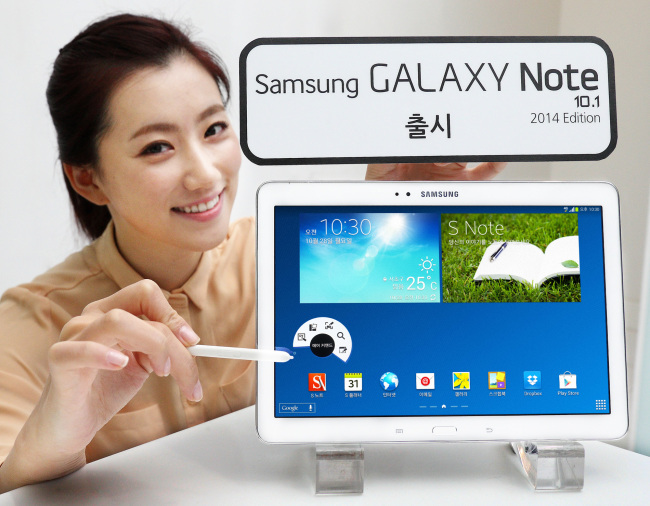 A model poses with the latest tablet Galaxy Note 10.1 2014 edition that goes on sale Friday.   Samsung Electronics