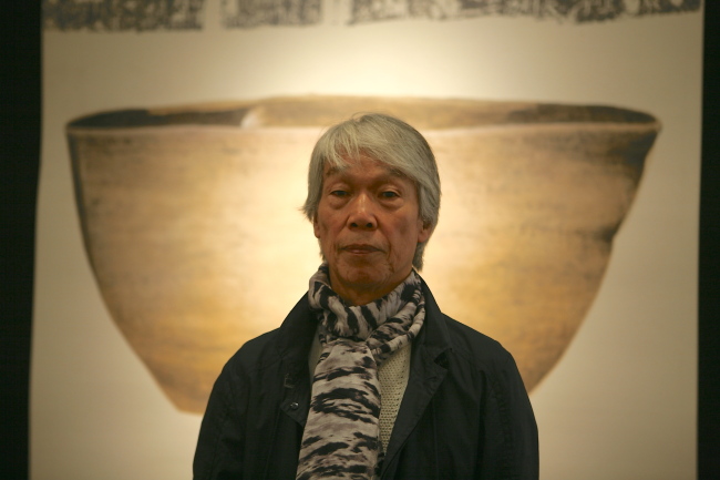 Artist Park Dae-sung poses in front of his painting at Gana Art Center.   Gana Art Center