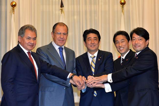 (From left) Russian Defense Minister Sergei Shoigu, Russian Foreign Minister Sergey Lavrov, Japanese Prime Minister Shinzo Abe, Japanese Foreign Minister Fumio Kishida and Japanese Defense Minister Itsunori Onodera join hands prior to their meeting in Tokyo on Saturday.   AFP-Yonhap News