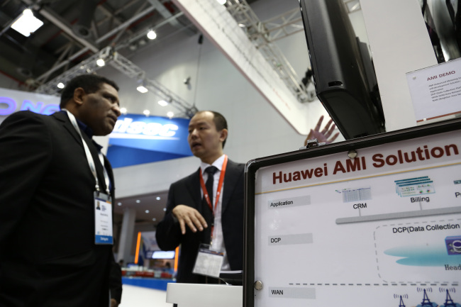 A Huawei Technologies Co. employee (right) speaks to an attendee at the company’s booth at the the 22nd World Energy Congress in Daegu on Oct. 16.   Bloomberg