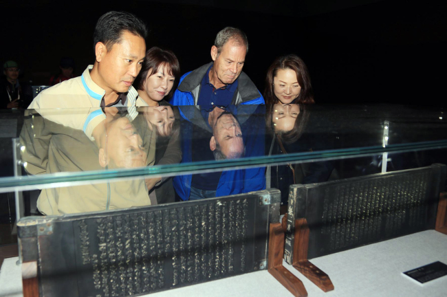 Tourists look at the wooden blocks of the Tripitaka Koreana on display at the 2013 Tripitaka Koreana Festival in Hapcheon, South Gyeongsang Province.   Yonhap News