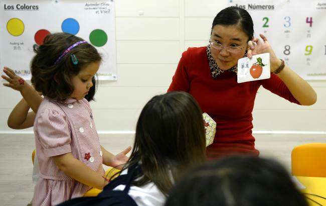 Chinese teacher Huijuan holds a flashcard during a Chinese lesson at TEO 2 kindergarten in Madrid.   AFP-Yonhap News