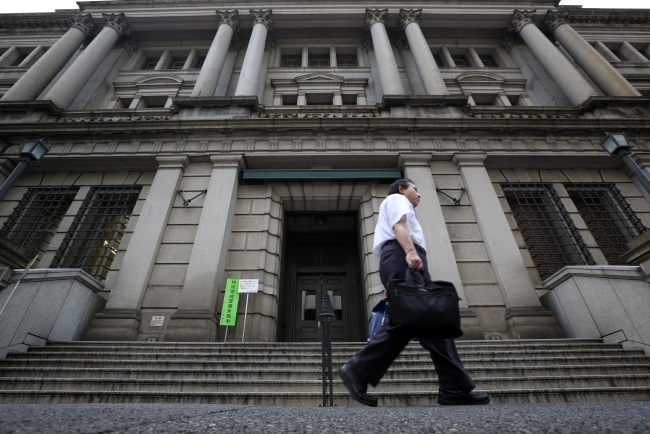 A pedestrian walks past the Bank of Japan headquarters in Tokyo.   Bloomberg