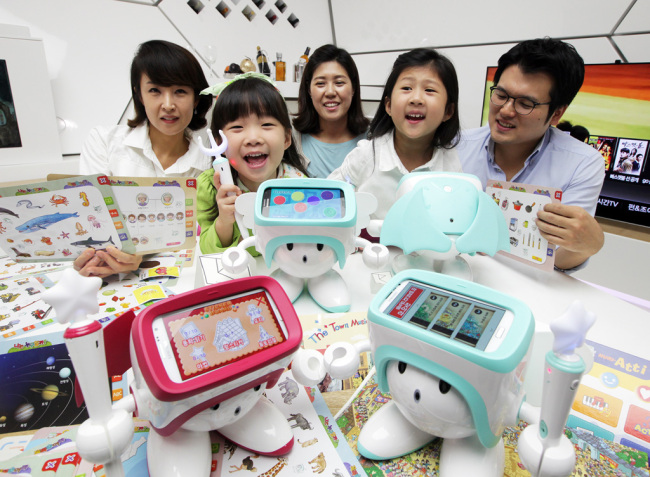 Children and their parents pose with SK Telecom’s smart robot “Atti.”   SKT