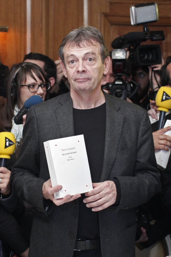 French writer Pierre Lemaitre poses with his book, “Au Revoir la-Haut,” after being awarded the 2013 Goncourt literary prize in Paris on Monday.   AP-Yonhap News