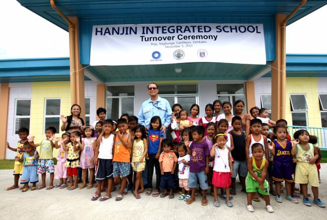 [사진설명=한진중공업 수빅조선소는 5일 오전 카스트롤시에 '한진종합학교(Hanjin integrated school)'을 기증하는 합의서(MOA)를 필리핀 교육부와 체결했다. 지난 6개월 간 공사를 거쳐 준공된 학교는 내년 5월부터 유치원부터 고등학교까지 전 과정을 운영하며 약 400여명의 학생을 수용할 예정이다. 안진규<사진 가운데> 수빅조선소 사장이 이날 체결식이 끝난 후 지역 아동들과 함께 학교 정문 앞에서 시간을 보내고 있다. (사진=한진중공업)]