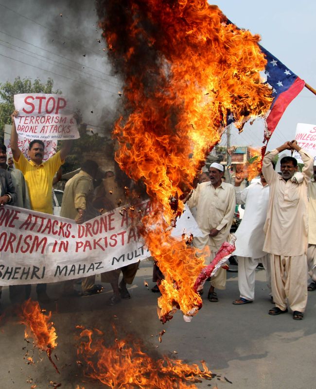 Pakistani protesters from United Citizen Action shout anti-U.S. slogans as they burn the U.S. flag during a protest against U.S. drone attacks in Pakistani tribal areas, in Multan on Oct. 31.   AFP-Yonhap News