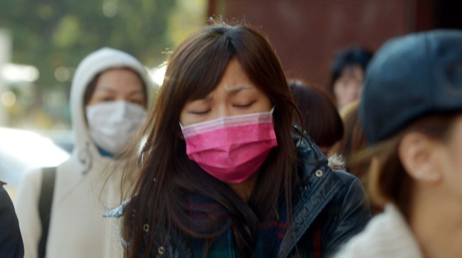 People walk in southern Seoul wearing face masks to protect against fine dust particles.   Kim Myung-sub/The Korea Herald