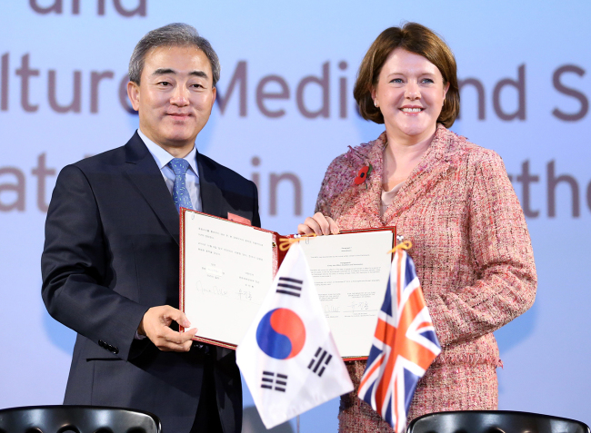 Korean Culture Minister Yoo Jin-ryong and British Secretary of State for Culture, Media and Sport and Minister for Women and Equalities Maria Miller pose for a photo after signing an MOU for cultural ties at the Cineworld Haymarket in London on Wednesday.   Yonhap News