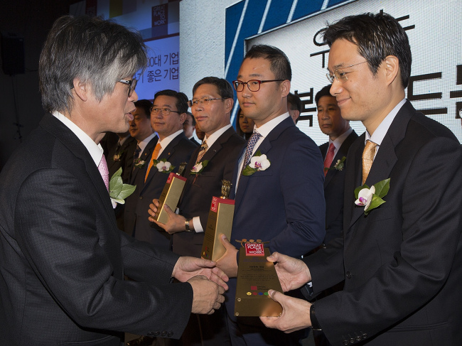 J.K. Kim (right), the country leader of Gore Korea, receives an award for “100 Best Companies to Work for in Korea” at a ceremony in Seoul on Thursday. Gore Korea