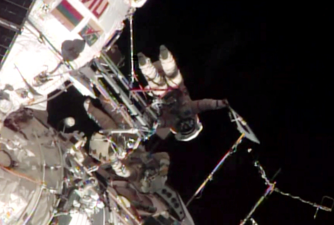 This screen image taken from NASA shows the Sochi Olympic torch being held during a spacewalk on Saturday.   AP-Yonhap News