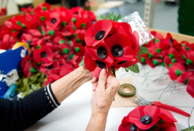 Iris Kellett assembling “A spray” version of the iconic red emblem of the British Legion’s annual poppy appeal at the company headquarters in Richmond, London.   AFP