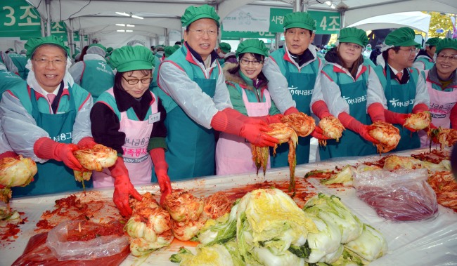 Hana Financial Group chairman Kim Jung-tai (fifth from left) and heads of its affiliates attend a kimchi-making event as part of its campaign for sharing at its headquarters on Monday. The participants included Korea Exchange Bank CEO Yun Yung-ro (left), group president Choe Heung-sik (third from left) and Hana Bank CEO Kim Jong-jun (seventh from left).   Kim Myung-sub/The Korea Herald