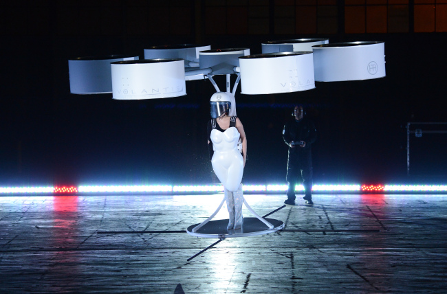 Lady Gaga demonstrates the Volantis transport prototype “flying dress” designed by TechHaus ― Studio XO during the “Artpop” album release and artRave event at the Brooklyn Navy Yard on Sunday in New York.   AP-Yonhap News