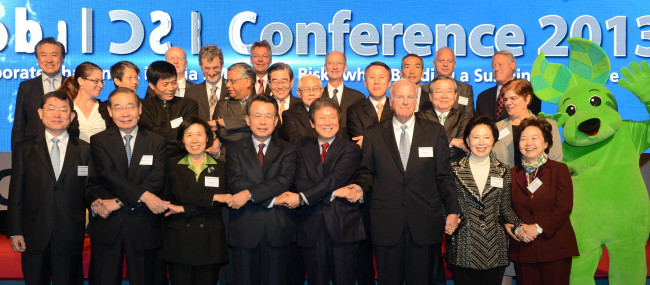 Lee Seung-han (fifth from left, front row), president of U.N. Global Compact Korea and chairman of Homeplus, joins hands with participants, including former Prime Minister Han Seung-soo (fourth from left, front row), chairman of the organizing committee for the conference, during the Global CSR Conference 2013 that kicked off in Seoul for a two-day run on Tuesday.   Lee Sang-sub/The Korea Herald