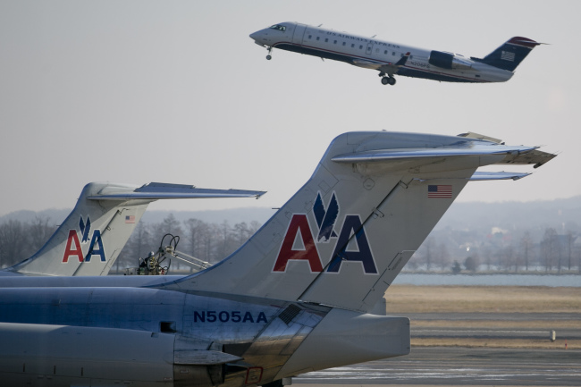 A US Airways Group Inc. airplane takes off behind AMR Corp.’s American Airlines airplanes at Reagan National Airport in Washington, D.C.   Bloomberg