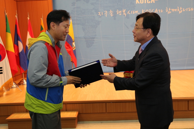 Oh Se-hoon (left), former Seoul mayor, receives a certificate of course completion from Kim Young-mok, president of KOICA, in a ceremony to launch its delegation of advisers to developing countries in Seoul on Friday.   KOICA