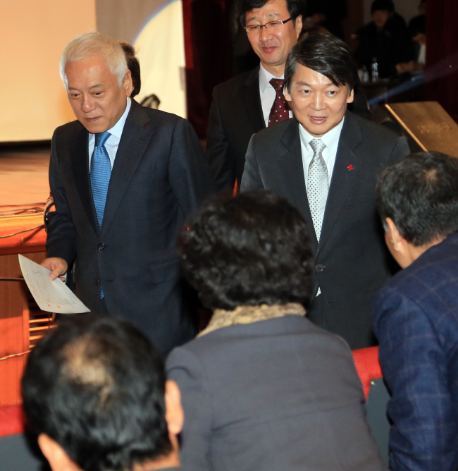Democratic Party chairman Kim Han-gil (left) and independent Rep. Ahn Cheol-soo greet participants while attending an event for democracy and peace held in Seoul, Sunday.   Yonhap News