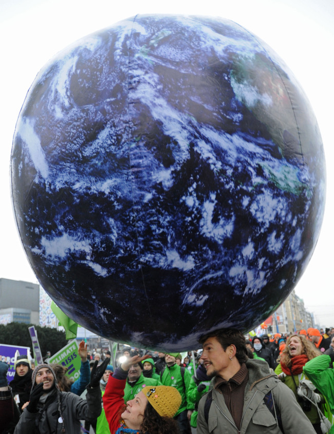 Climate activists play with a giant globe during an environmentalist march against global warming in downtown Warsaw, Poland, Saturday. The demonstration coincides with a two-week United Nations conference that is to prepare the ground for a new climate deal expected in 2015.   AP-Yonhap News