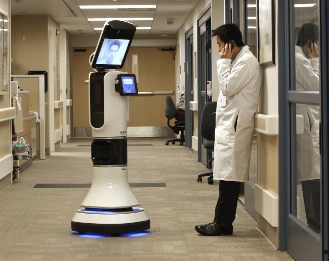 Dr. Alan Shatzel, medical director of the Mercy Telehealth Network, is displayed on the monitor RP-VITA robot as he waits to confer with Dr. Alex Nee at Mercy San Juan Hospital in Carmichael, California.   AP-Yonhap News