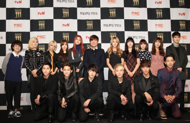FNC Entertainment CEO Han Sung-ho (center, second row) poses with members of the label’s artists at the “Cheongdamdong 111” press conference in Seoul on Monday.   CJ E&M