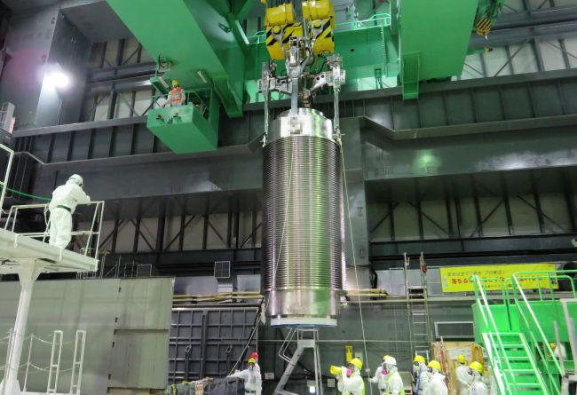 This handout picture taken by Tokyo Electric Power Co. on Monday shows a cask (center) of nuclear fuel being lifted and moved by TEPCO workers during an exercise to remove fuel rods from a pool at the unit four reactor building of TEPCO’s Fukushima Dai-ichi nuclear power plant in the town of Okuma in Fukushima prefecture.   AFP-Yonhap News
