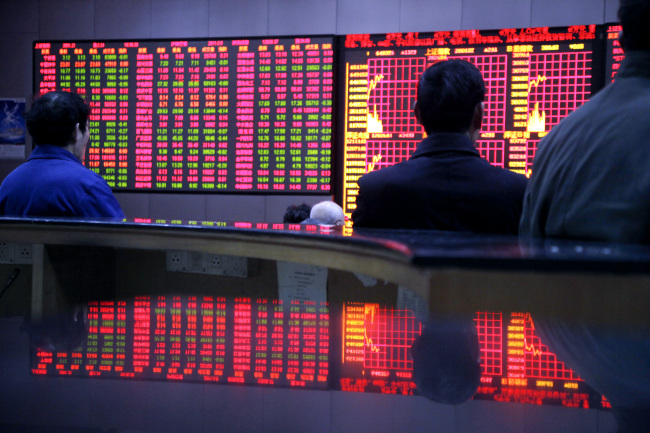 Investors monitor and trade stocks at a securities exchange in Shanghai.    Bloomberg