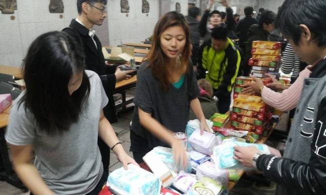 Volunteers pack supplies for victims of Typhoon Haiyan at Hyehwa Catholic Church on Sunday.   PIKO