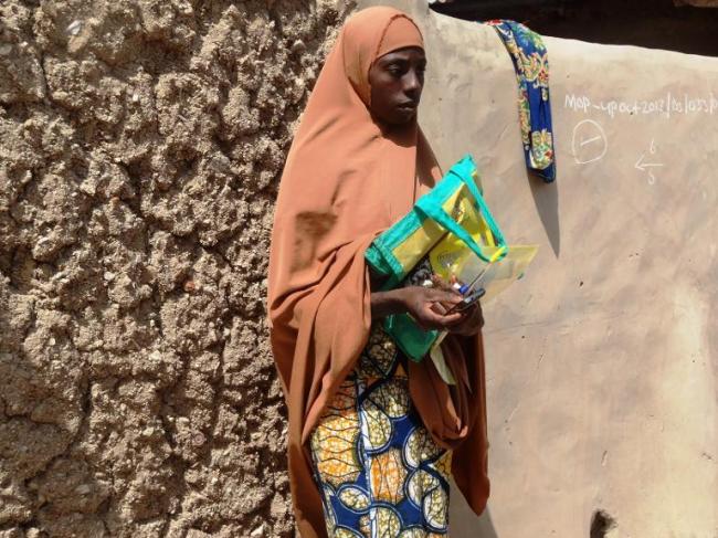 A polio vaccinator holds a phone tracking device in the Dawanau district of Kano, northern Nigeria.   AFP